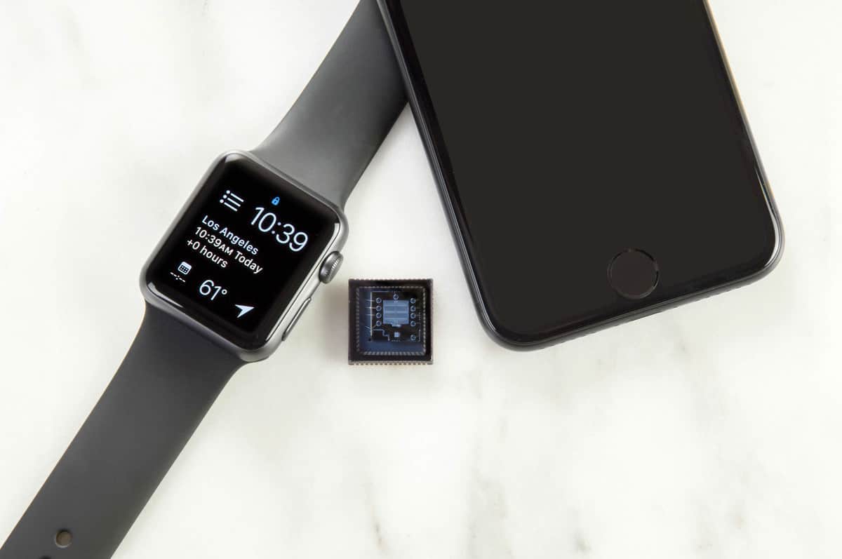 a microchip sits next to an iwatch and iphone in 2019